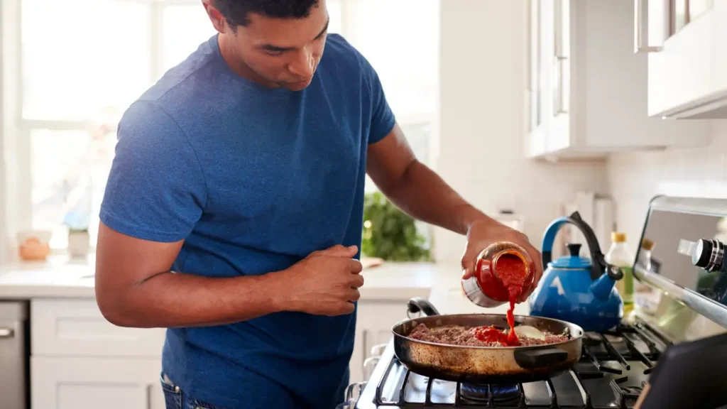 Pessoa cozinhando com gás GLP.