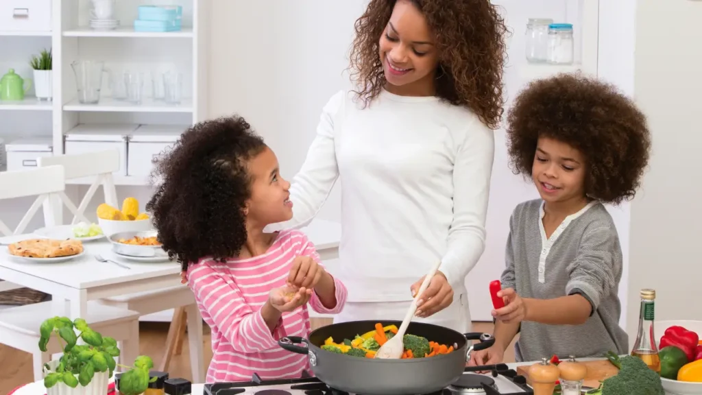 Mãe com dois filhos cozinhando juntos.